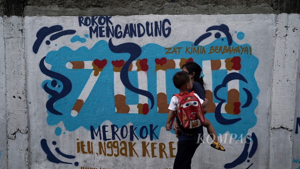 Warga melintasi mural bahaya rokok di Jalan Lontar, Jagakarsa, Jakarta Selatan, Minggu (13/12/2020).