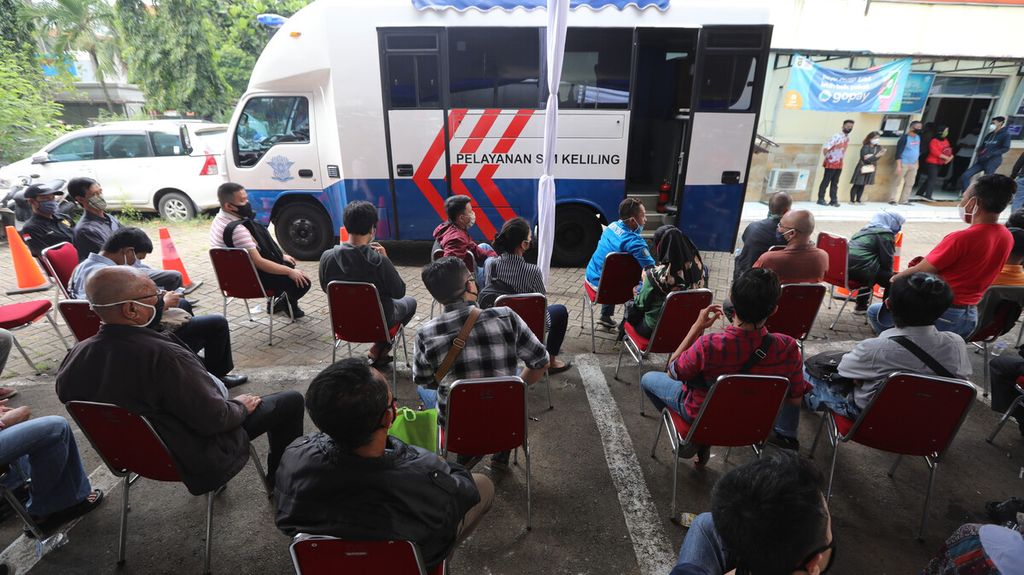 Warga mengantre untuk mengurus perpanjangan SIM di kantor pelayanan Samsat Jakarta Timur, Rabu (3/6/2020). Pihak Samsat menggunakan mobil layanan keliling untuk mengatasi gangguan jaringan.