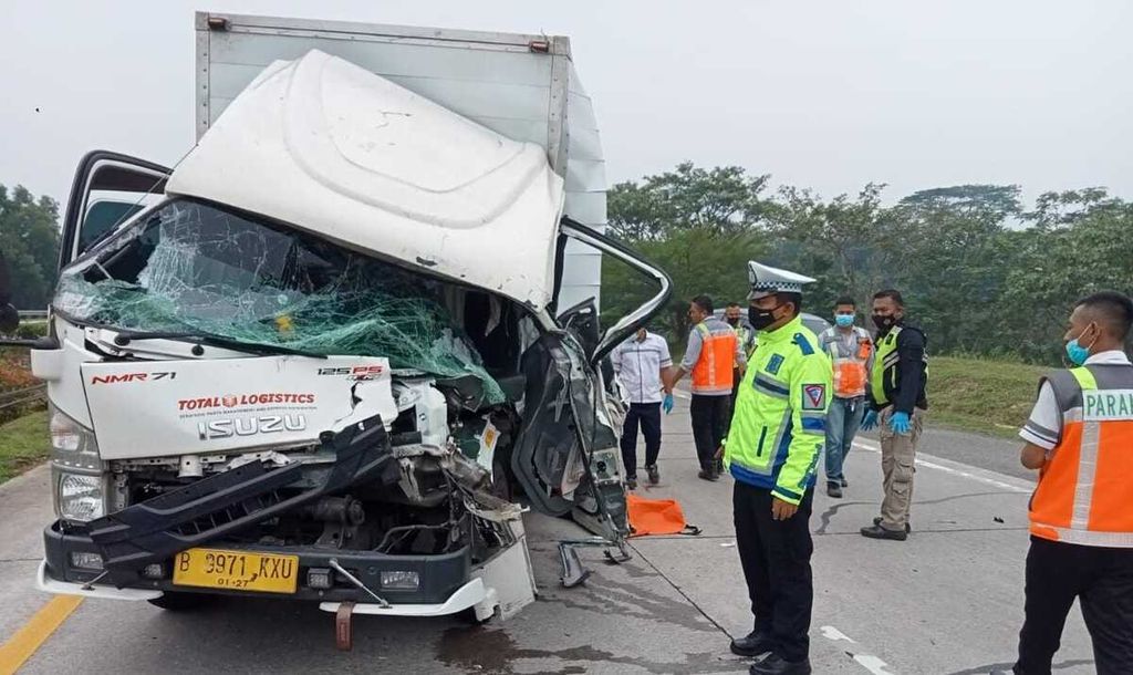 Polisi mengecek truk boks Isuzu bernomor polisi B 9971 KXU yang terlibat kecelakaan di Tol Cikopo-Palimanan Kilometer 91+700, Kabupaten Subang, Jawa Barat, yang mengarah ke Cikopo, 11 Oktober 2022. Seorang meninggal dan seorang lainnya terluka dalam kecelakaan tabrak belakang itu.