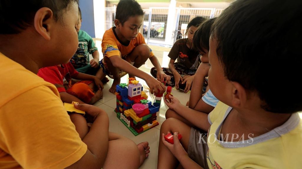 Bermain Selain Gawai-Sekelompok anak-anak menyusun permainan "bricks" di Ruang Publik Terpadu Ramah Anak (RPTRA) Rusun Komarudin, Jakarta, Selasa (24/7/2018). Permainan "bricks" yang tersedia di RPTRA dan dapat dimainkan oleh semua anak dapat menjadi alternatif bermain yang merangsang kreativitas serta mengurangi demam gawai yang kini melanda generasi belia.