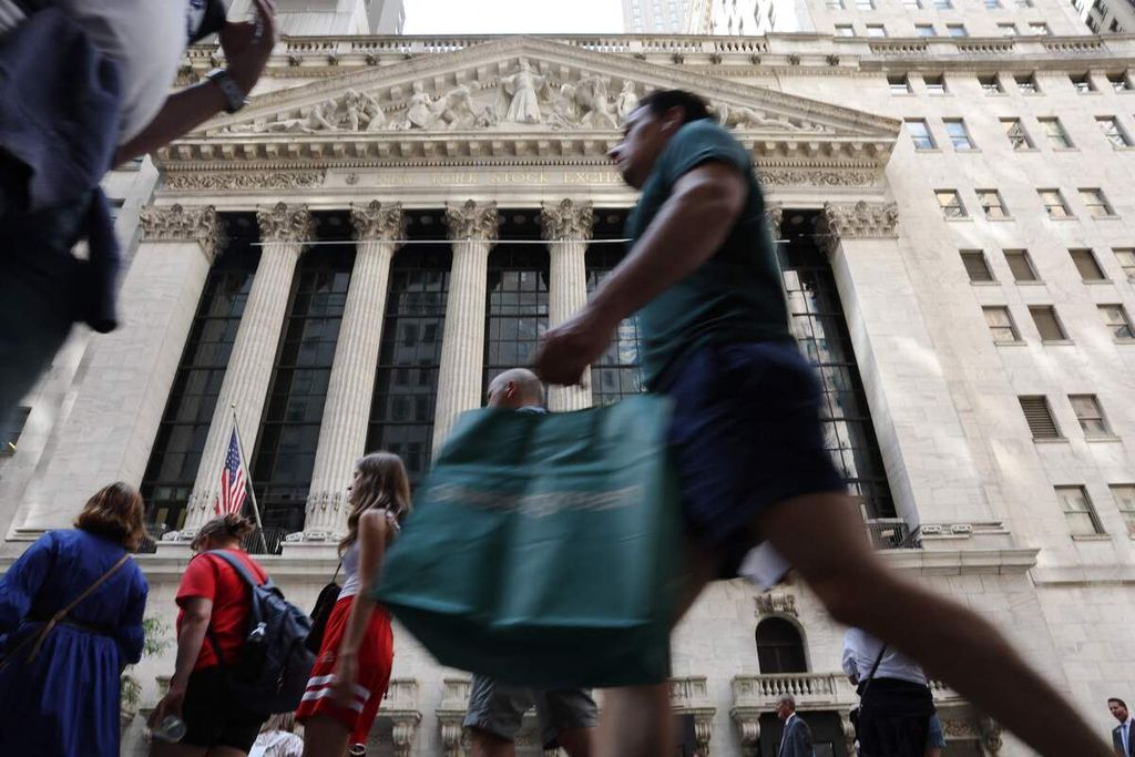 Warga berjalan melintas di depan the New York Stock Exchange di New York City pada 2 Agustus 2023.