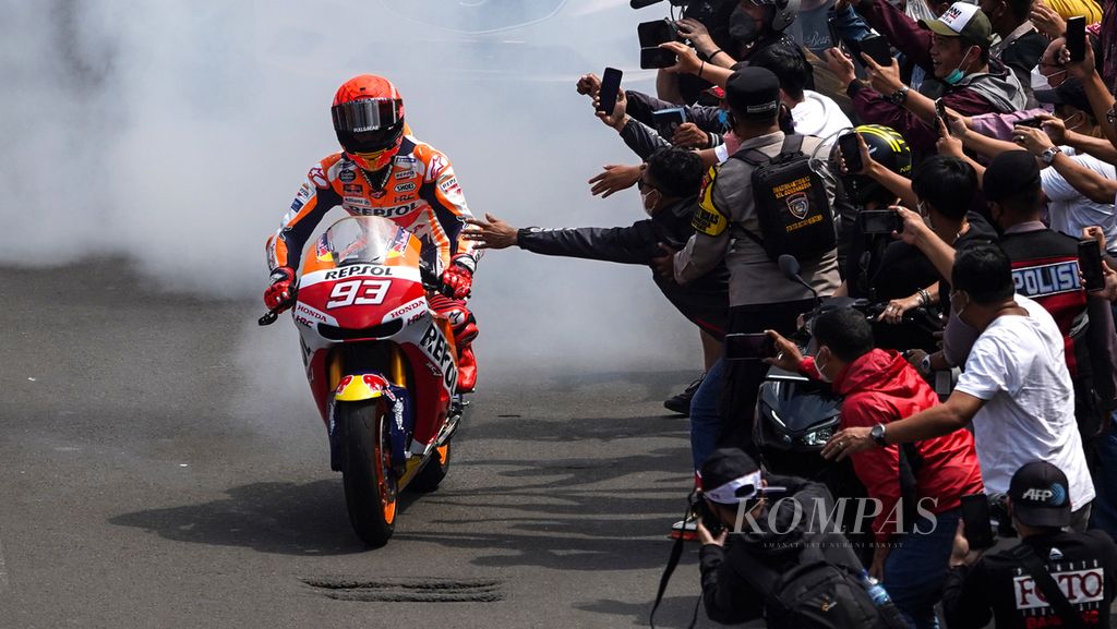 Pebalap Marc Marquez melakukan aksi <i>burn out </i>untuk membalas sambutan warga ketika menanti pebalap MotoGP beriring melintasi Jalan MH Thamrin, Jakarta, Rabu (16/3/2022).  