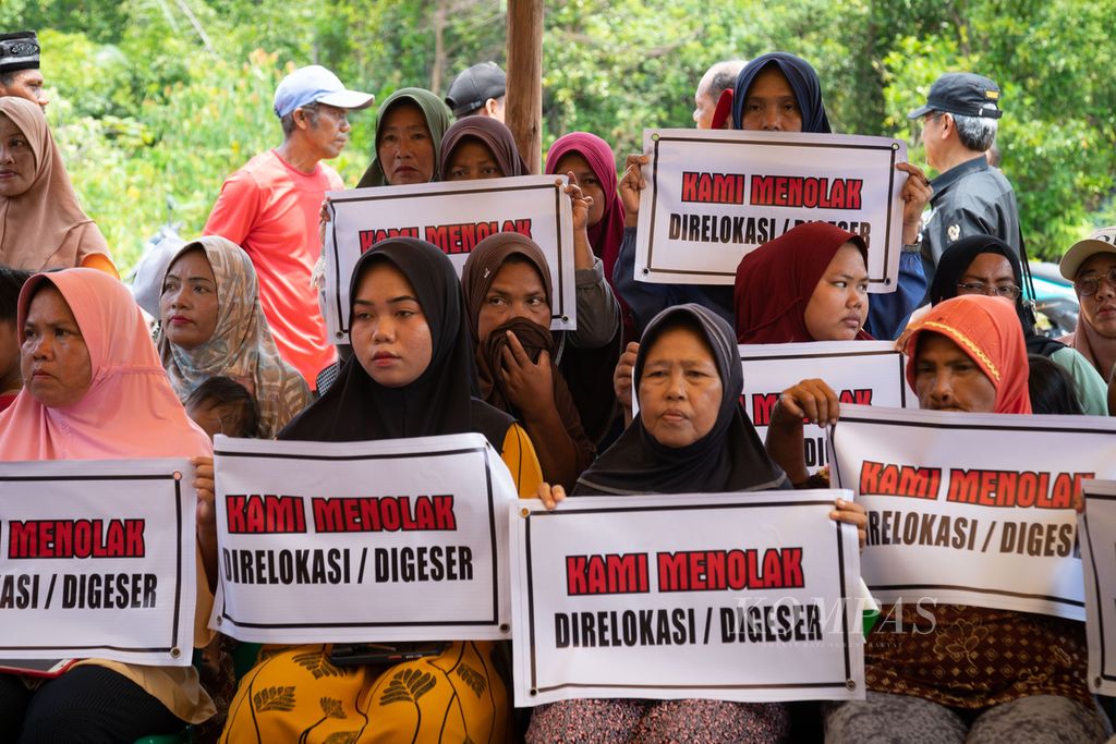Para perempuan Rempang memegang spanduk penolakan relokasi di Posko Pendampingan Hukum Kampung Pasir Panjang, Pulau Rempang, Batam, Kepulauan Riau, Kamis (5/10/2023).