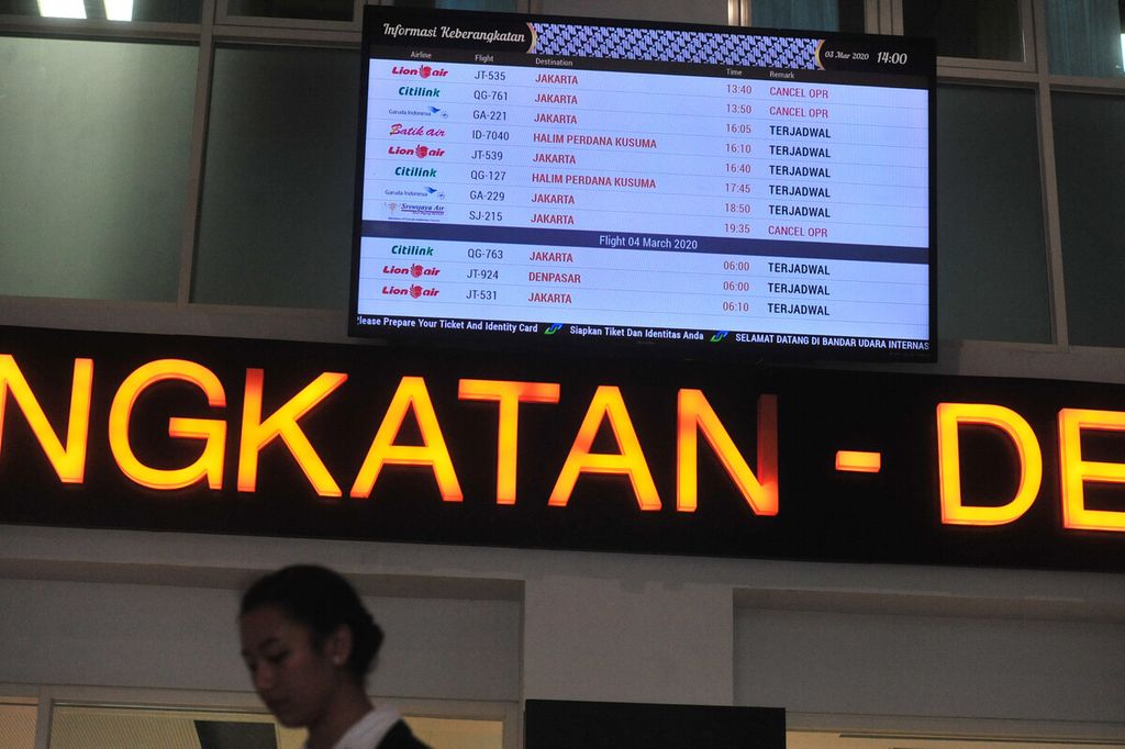  Informasi penundaan sejumlah penerbangan ditayangkan di pintu masuk terminal keberangkatan di Bandara Adi Soemarmo, Boyolali, Jawa Tengah, Selasa (3/3/2020). 