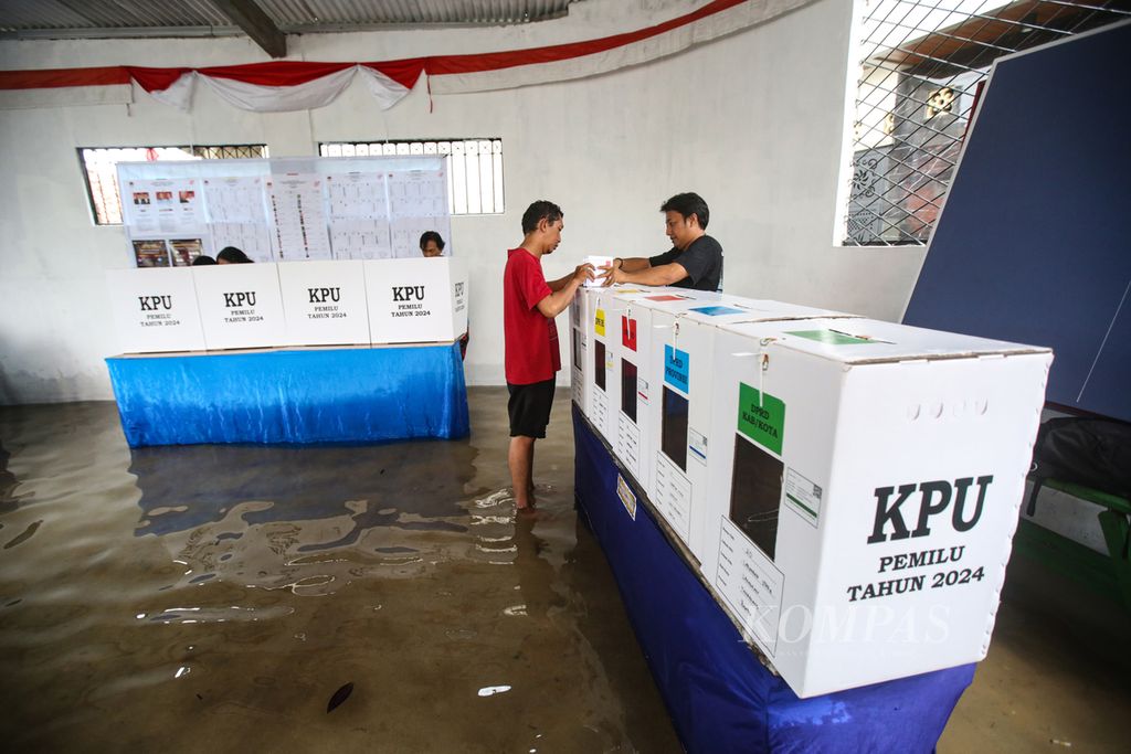 Warga menyalurkan suaranya pada Pemilu 2024 di TPS 20 yang terendam banjir di Kelurahan Larangan Utara, Larangan, Kota Tangerang, Banten, Rabu (14/2/2024). 