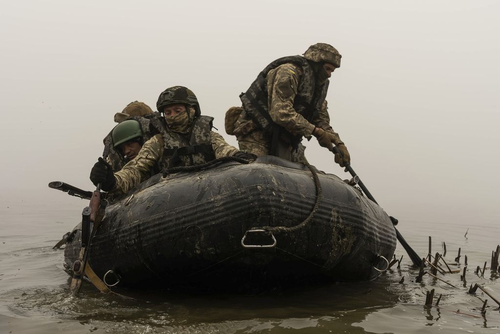 Para anggota marinir Ukraina naik perahu karet di Sungai Dnipro di garis depan pertempuran dekat Kherson, Ukraina, 14 Oktober 2023. 