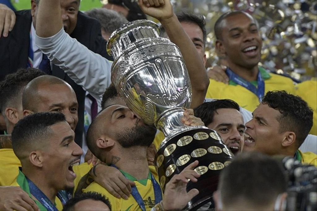 Kapten Brasil, Dani Alves, mencium trofi Copa America setelah mengalahkan Peru pada babak final dengan skor 3-1 di Stadion Maracana, Rio De Janeiro, Brasil, Senin (8/7/2019). Ia menjadi pesepak bola pertama yang mampu meraih 40 trofi. 