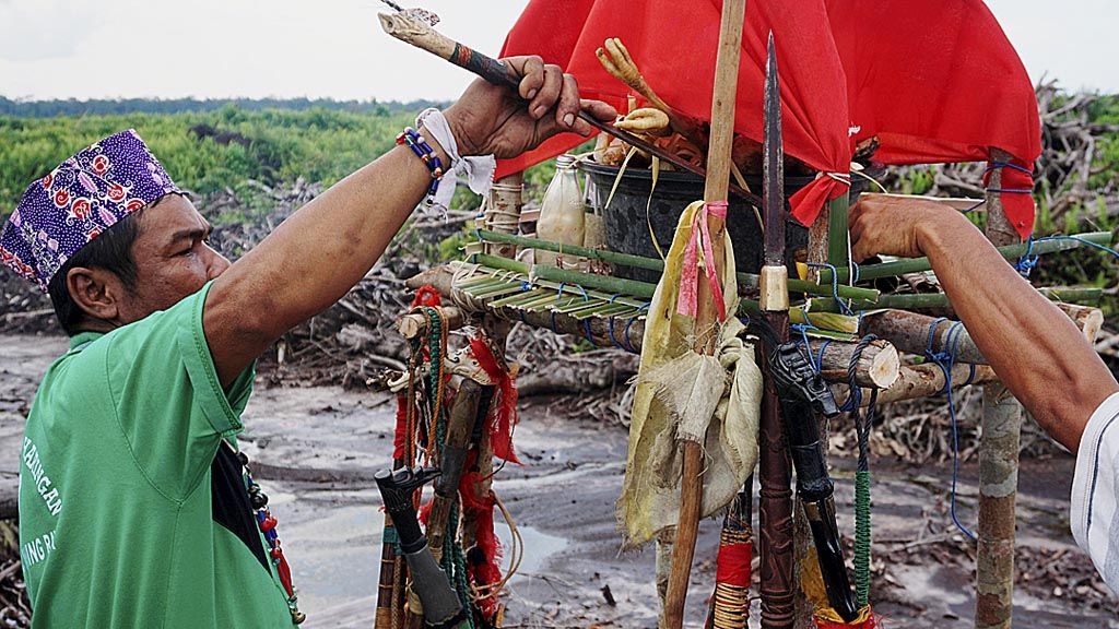 Upu Ucun Tirunuk, basir atau pemuka agama Kaharingan, kepercayaan masyarakat suku Dayak,  memulai upacara adat hinting pali di Desa Lawang Uru, Kabupaten Pulang Pisau  (foto bawah).