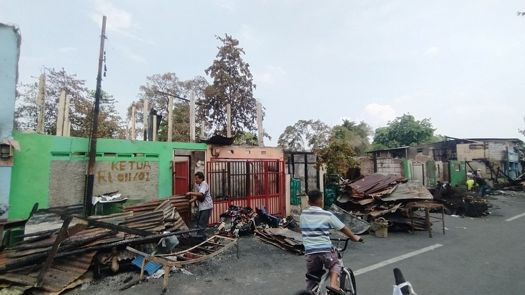 Sejumlah warga RT 011 RW 001 Kelurahan Manggarai, Kecamatan Tebet, Jakarta Selatan, Minggu (18/12/2022), membersihkan puing-puing sisa bangunan yang terbakar. Berdasarkan data sementara, sejumlah 14 rumah induk, yang terdiri atas 59 bilik kontrakan, hangus dilalap si jago merah pada Sabtu (17/12/2022).