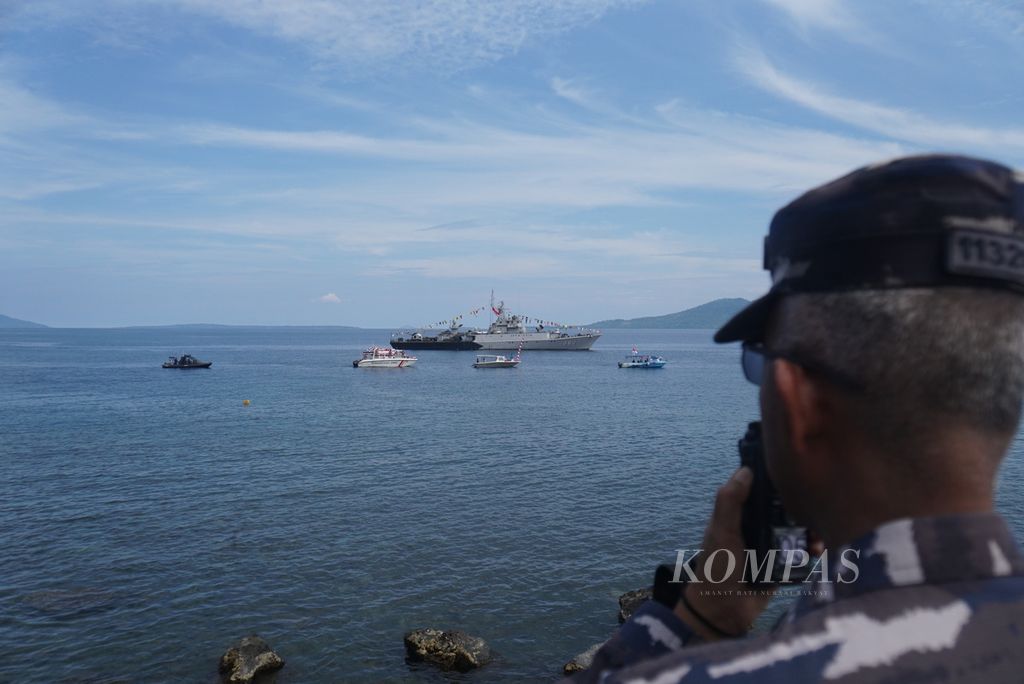 Seorang tentara Angkatan Laut berkomunikasi dengan awak Kapal Republik Indonesia (KRI) Hasan Basri 382 dalam parade pembukaan Festival Pesona Bunaken, Rabu (2/11/2022), di Pantai Malalayang, Manado, Sulawesi Utara,