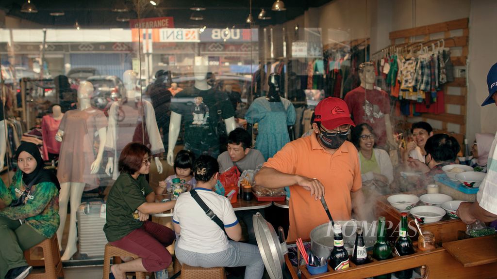 Pelancong menikmati kuliner kaki lima di trotoar Jalan Suryakancana, Kota Bogor, Jawa Barat, Minggu (15/5/2022). 