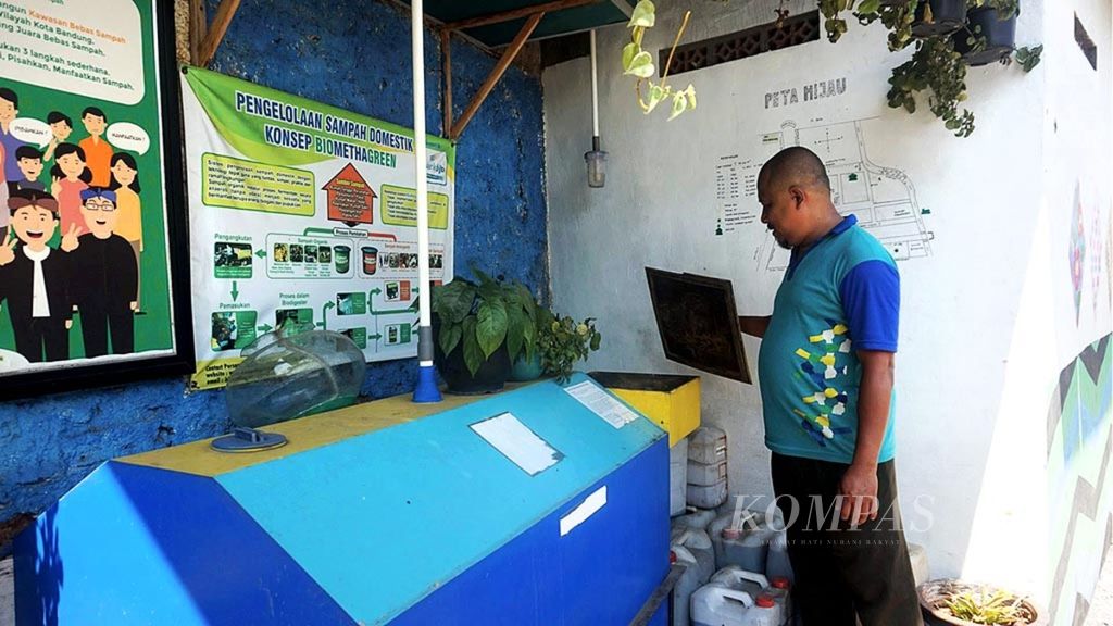 Asep Damyati (42) memeriksa biodigester di samping Balai RW 009 Cigareleng, Bandung, Jawa Barat, Rabu (15/8/2018).