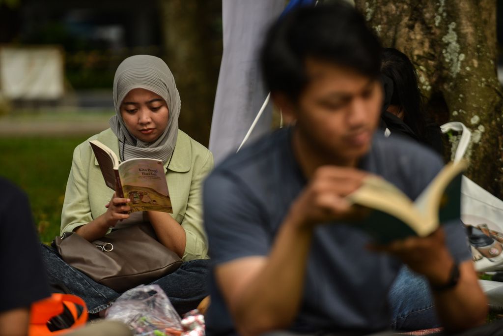 Para pegiat literasi asyik menghabiskan waktu sore dengan membaca buku di kawasan Taman Lapangan Banteng, Jakarta Pusat, Sabtu (27/5/2023). Taman ini menjadi salah satu tempat warga menghabiskan waktu akhir pekan dengan beragam aktivitas. Sebagian warga memilih membaca buku bersama dan berdiskusi. 