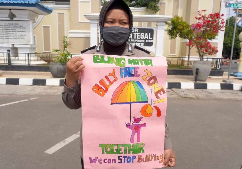 Polisi wanita Polres Tegal Kota membawa poster berisi pesan terkait bahaya perundungan siber dalam kampanye melawan kekerasan terhadap anak, Kamis (23/7/2020), di Kota Tegal, Jawa Tengah. Kampanye tersebut dilakukan dalam rangka memperingati Hari Anak Nasional.