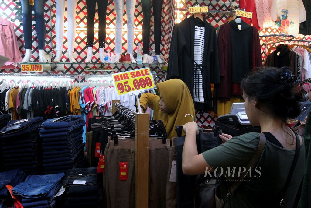 Konsumen melihat dan mencoba barang yang ditawarkan pedagang kemeja dan busana di Blok M Square, Jakarta, Senin (3/6/2019).