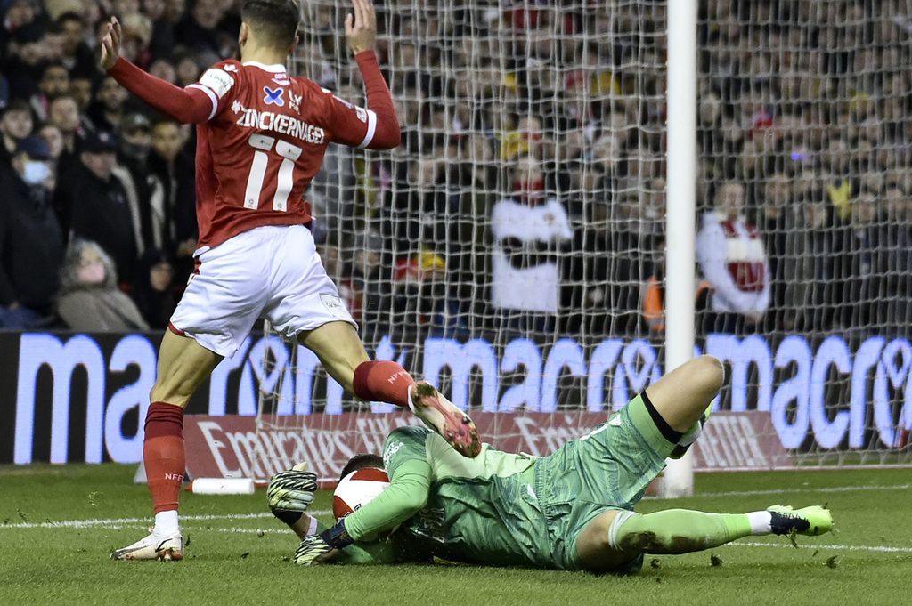 Kiper Arsenal, Bernd Leno (kanan), membuat penyelamatan dari usaha penyerang Nottingham Forest, Philip Zinckernagel, untuk mencetak gol dalam babak ketiga Piala FA di Stadion City Ground, Nottingham, Inggris, Senin (10/1/2022) dini hari WIB. Leno menjadi pemain yang dilepas Arsenal ke Fulham dalam rangka perampingan skuad ”Si Meriam”.