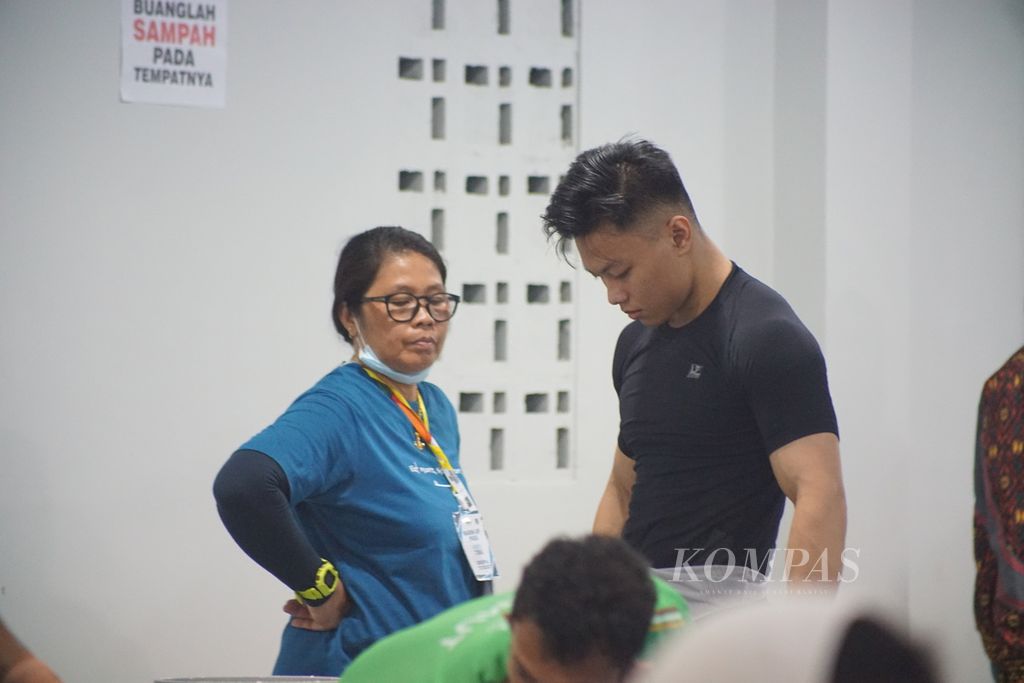 Lifter nasional asal Sulawesi Selatan, Rahmat Erwin Abdullah, didampingi ibunya yang juga mantan lifter nasional, Ami Asun Budiono, saat tampil di kelas 73 kilogram angkat besi PON Aceh-Sumut 2024 di GOR Seuramoe, kompleks Stadion Harapan Bangsa, Aceh, Kamis (5/9/2024).