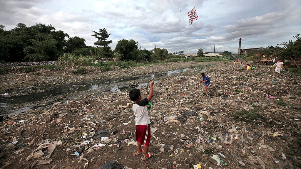 Anak-anak bermain di atas endapan sampah di aliaran Sungai Citarum Lama di Rancamanyar, Bandung, Jawa Barat, Jumat (19/1/2018). 