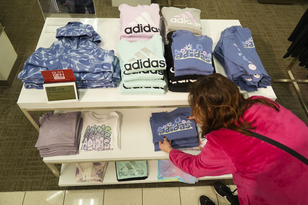 Pekerja toko Kohl's yang terletak di New Jersey, Jumat (26/1/2024), merapikan pakaian yang diletakkan di atas meja. 