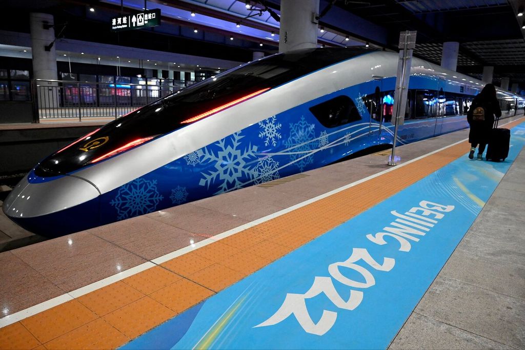 Seorang penumpang berjalan di kereta peluru yang baru diluncurkan yang akan membawa atlet ke tempat Olimpiade Musim Dingin Beijing 2022, di Stasiun Qinghe, Beijing, China, Jumat (21/1/2022). 