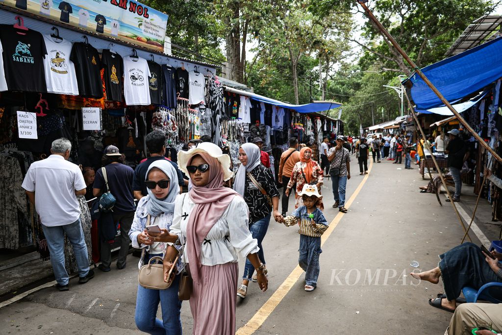 Wisatawan melintasi deretan lapak pedagang di kawasan Tugu Kilometer Nol, Sabang, Aceh, Sabtu (14/9/2024). Penyelenggaraan PON Aceh-Sumut 2024 berdampak positif pada sektor pariwisata di Sabang, salah satunya Tugu Kilometer Nol. 