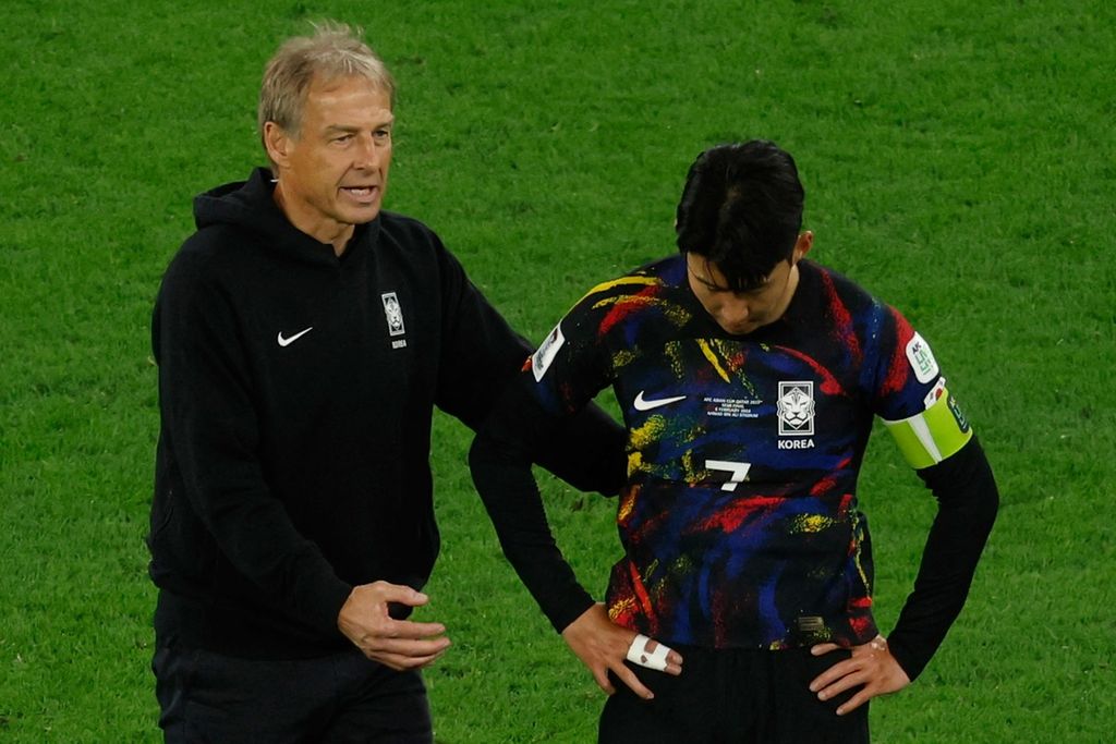 Pelatih Korea Selatan Juergen Klinsmann berbicara dengan kapten Son Heung-min usai kalah dari Jordania pada semifinal Piala Asia 2023, Selasa (6/2/2024). 