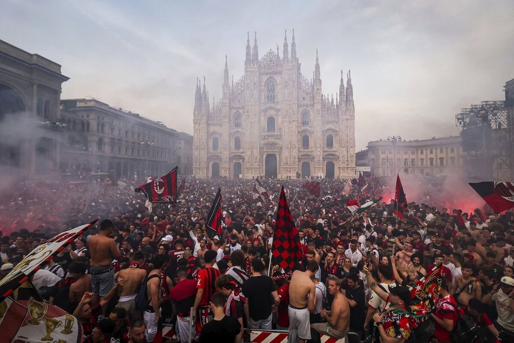 Fans AC Milan merayakan gelar <i>scudetto </i>di alun-alun Piazza Duomo, Milan, Minggu (22/5/2022). AC Milan memastikan gelar Serie A Liga Italia dalam 11 tahun terakhir dengan kemenangan 3-0 atas Sassuolo.