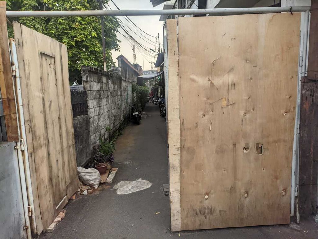 Gerbang masuk yang dipertebal dengan lapisan kayu dibangun warga RW 007 untuk mengantisipasi dampak tawuran pemuda meluas ke wilayahnya di kawasan Cipinang Utara Besar, Jatinegara, Jakarta Timur, Kamis (1/6/2023). 