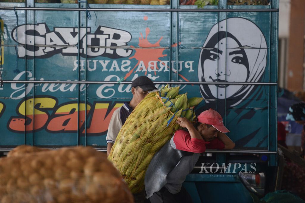 Buruh mengangkut sayur yang akan dikirim dari Pasar Sayur Cepogo, Kecamatan Cepogo, Boyolali, Jawa Tengah, Maret 2020.