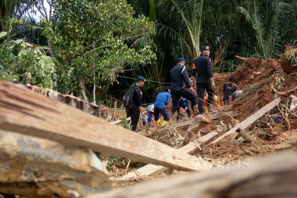 Anggota Brimob Polda Kepulauan Riau berupaya mengevakuasi korban meninggal akibat longsor di Kampung Genting, Desa Pangkalan, Kecamatan Serasan, Kabupaten Natuna, Kepulauan Riau, Kamis (9/3/2023).