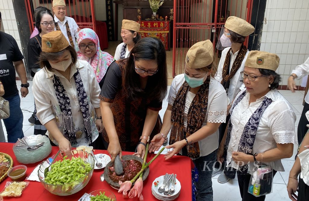 Para peserta dalam peringatan Tragedi Mei 1998 mengulek sambal rujak kecombrang yang akan dimakan dengan pare di Boen Hian Tong, Kelurahan Kranggan, Kecamatan Semarang Tengah, Kota Semarang, Jawa Tengah, Minggu (21/5/2023). 