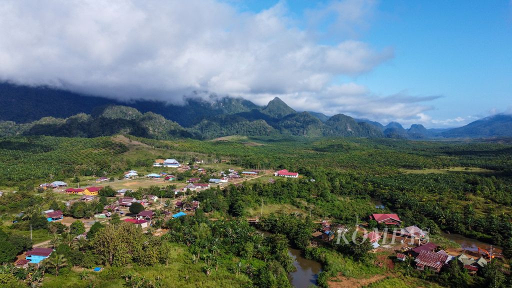 Rimbun pohon sawit dan pegunungan mengelilingi Desa Lalomerui, Routa, Konawe, Sulawesi Tenggara, seperti terlihat dari ketinggian pada Jumat (22/7/2022). 