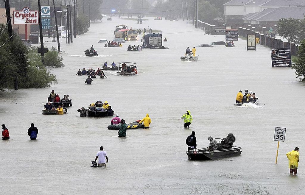 Perahu penyelamat hilir mudik di jalanan yang digenangi banjir saat mengevakuasi warga yang dilanda banjir di Houston, Texas, Amerika Serikat, Senin (28/8). Setidaknya 30.000 warga dievakuasi akibat banjir yang menyertai hantaman topan Harvey, akhir pekan lalu.