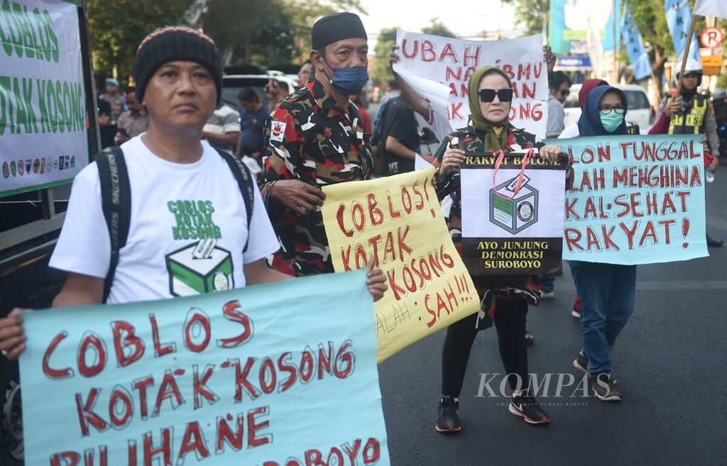 Dengan membawa poster, warga dari Gerakan Coblos Kotak Kosong berunjuk rasa di depan Kantor DPRD Surabaya, Jawa Timur, Selasa (17/9/2024). 