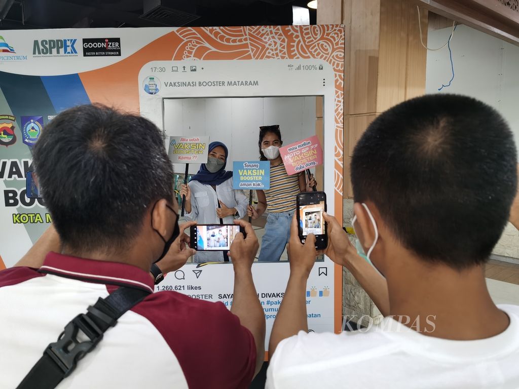 Warga Kota Mataram, Nusa Tenggara Barat, berfoto seusai menerima vaksin penguat dalam kegiatan vaksinasi di wilayah Kota Mataram di Epicentrum Mall Mataram, Sabtu (29/1/2022). Sejak 19 Januari 2022, NTB memulai pemberian vaksin ketiga dengan target sasaran sebanyak 600.000 orang. Percepatan vaksinasi ketiga di daerah tersebut juga bagian dari persiapan menyambut gelaran MotoGP pada 18-20 Maret 2022.