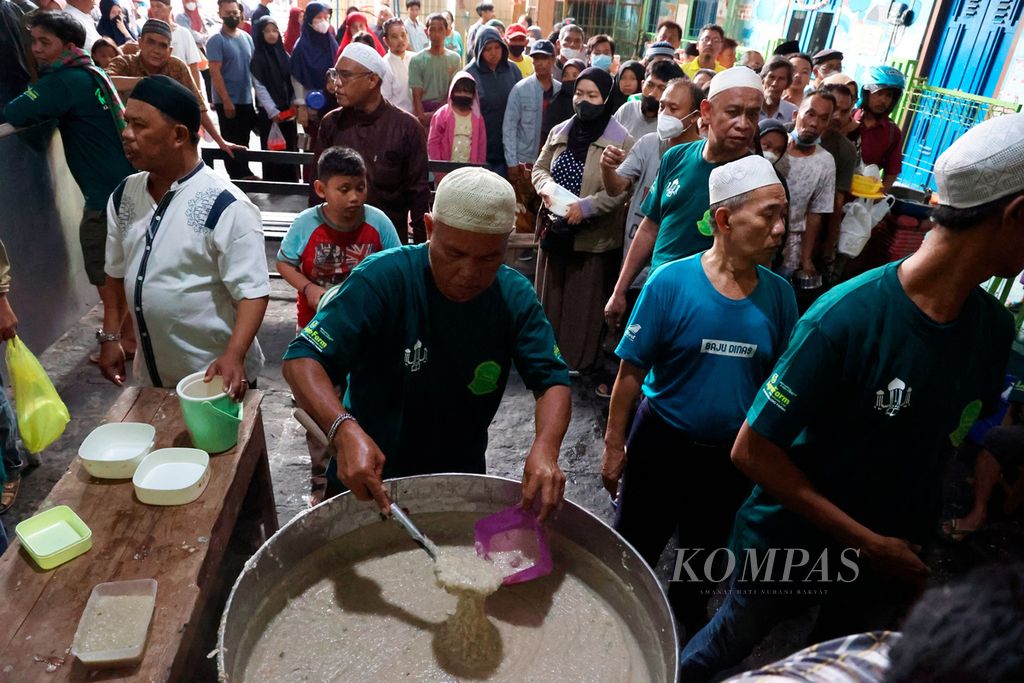 Petugas membagikan bubur samin untuk warga yang menjadi tradisi selama bulan Ramadhan di Masjid Darussalam, Kampung Jayengan, Kota Surakarta, Jawa Tengah, Kamis (23/3/2023). 