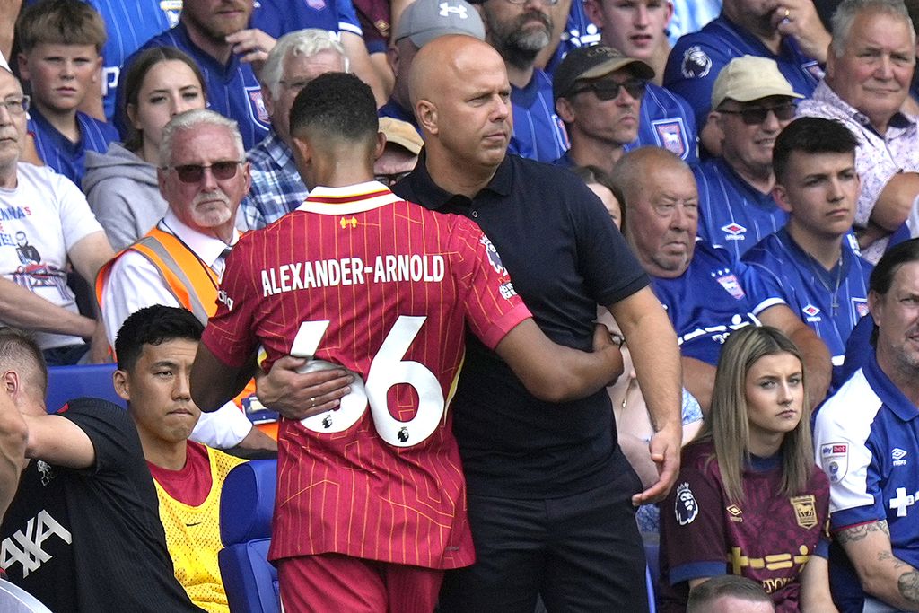 Manajer Liverpool Arne Slot memeluk Trent Alexander-Arnold saat Slot menariknya ke bangku cadangan ketika melawan Ipswich Town pada laga Liga Inggris di Stadion Portman Road, Ipswich, Sabtu (17/8/2024). 