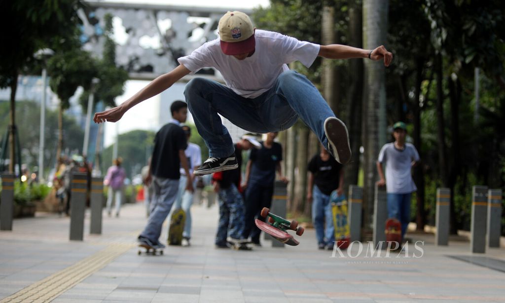  A young man demonstrates his skateboarding skills on the sidewalk of Sudirman-Thamrin street, Jakarta, Friday (12/3/2021).