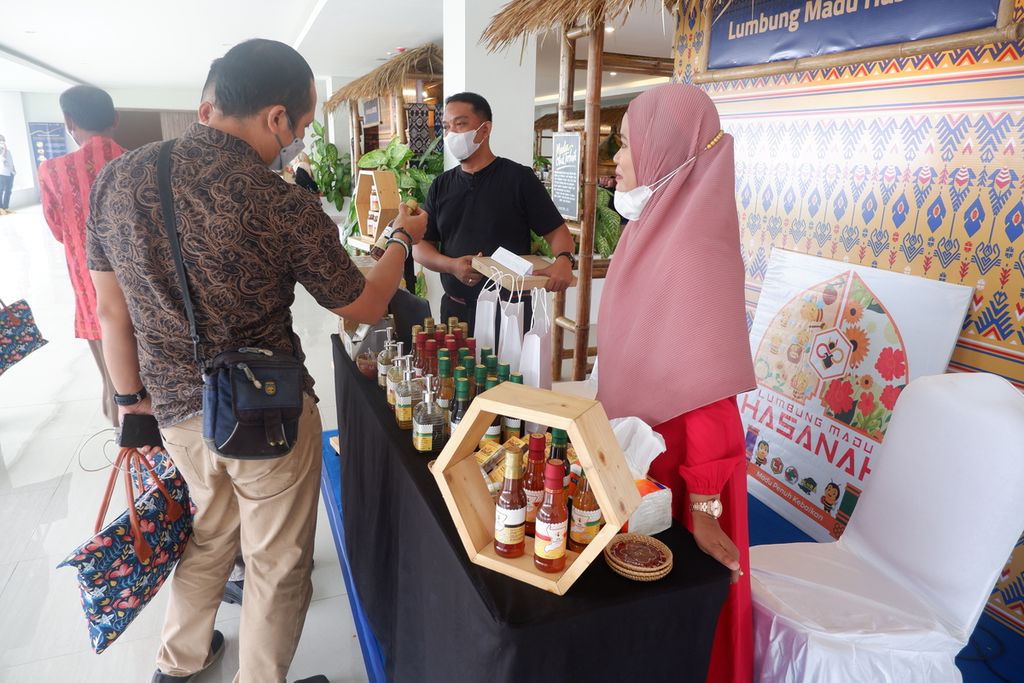 Peserta membeli produk usaha mikro, kecil, dan menengah (UMKM) yang membuka gerai pada Konferensi Internasional Mandalika ”Infinity Experiences of Nature and Sport Tourism” yang diselenggarakan Kementerian Pariwisata dan Ekonomi Kreatif/Badan Pariwisata dan Ekonomi Kreatif RI bekerja sama dengan harian <i>Kompas </i>di kawasan Kuta Mandalika, Pujut, Lombok Tengah, Nusa Tenggara Barat, Rabu (1/12/2021). Konferensi yang berlangsung dalam format daring dan luring tersebut membicarakan potensi besar Mandalika sebagai destinasi super prioritas, khususnya lewat ajang <i>sport tourism,</i> seperti balap MotoGP..