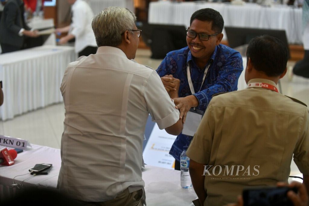 Saksi dari TKN 01, I Gusti Putu Artha, menyalami saksi dari BPN 02 saat penetapan hasil rekapitulasi nasional perolehan suara Pemilu 2019 di Gedung KPU, Jakarta, Selasa (21/5/2019) dini hari. 
