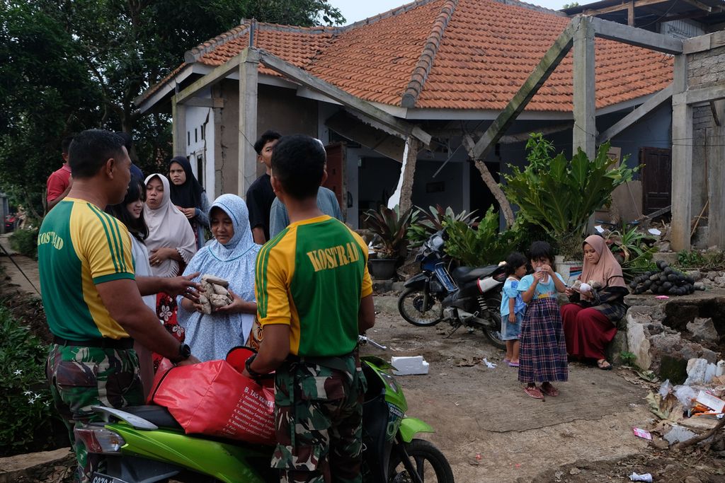 Soldiers from the 1st Transportation and Supplies Battalion of Cibinong Kostrad bring food to the victims of the Cianjur earthquake in Cileungsi Village, Sukajaya Village, Cugenang District, Cianjur Regency, Tuesday (29/11/2022).