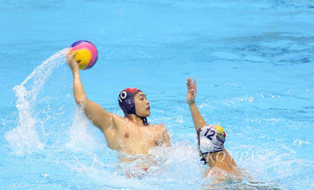 Pemain polo air Indonesia, Ridjkie Mulia, berusaha melempar bola dalam pertandingan polo air Indonesia lawan Thailand di SEA Games 2019. Pertandingan berlangsung di New Clark City, Filipina, 27 November 2019.