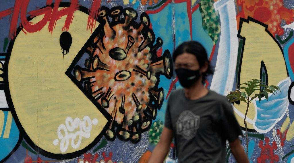 Warga melintasi mural tentang Covid-19 di Sunter, Tanjung Priok, Jakarta Utara, Senin (23/11/2020). 