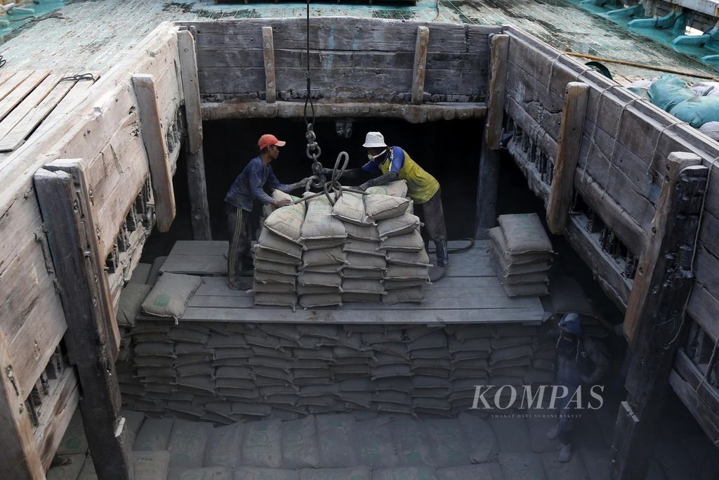 Buruh menindahkan semen ke dalam lambung kapal pinisi untuk dikirim ke Kalimantan, di Pelabuhan Sunda Kelapa, Jakarta, Rabu (8/11/2023). 