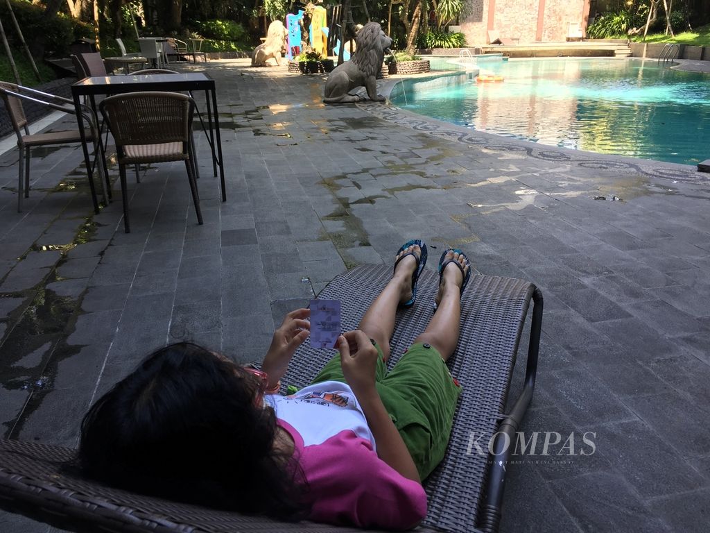 Menikmati suasana di tepi kolam renang hotel di Malang, Jawa Timur, 3 Mei 2021. 