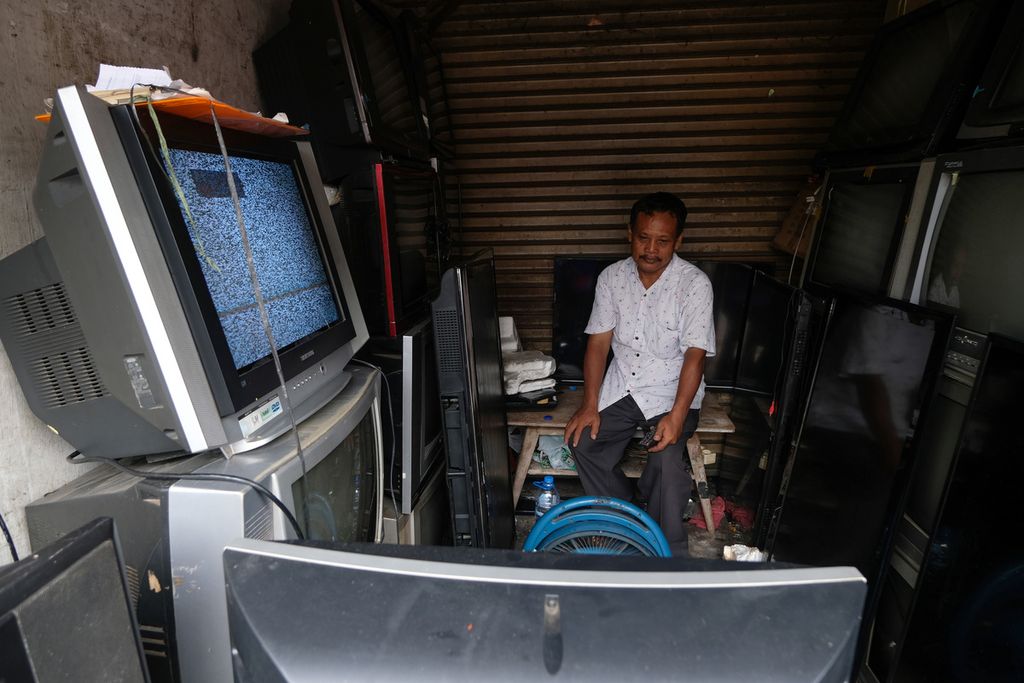 Salah satu penjual televisi bekas menyaksikan televisi yang sudah menggunakan siaran digital di Jalan Kembang Sepatu, Jakarta Pusat, Kamis (3/11/2022). Kementerian Komunikasi dan Informasi mematikan siaran televisi analog pada Rabu (2/11) sebagai upaya migrasi televisi analog menuju digital. 
