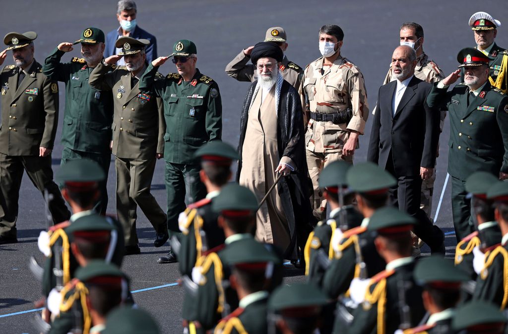 Foto yang dirilis Kantor Pemimpin Tertinggi Iran, Senin (3/10/2022), memperlihatkan pemimpin tertinggi Iran Ayatollah Ali Khamenei (tengah) menginspeksi pasukan saat menghadiri upacara kelulusan taruna kepolisian di Teheran, Iran. 