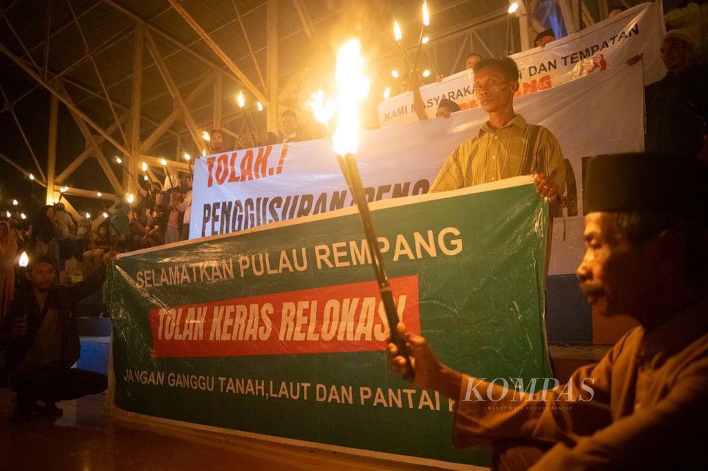 Warga membentangkan spanduk penolakan relokasi terkait proyek strategis nasional di Pulau Rempang, Batam, Kepulauan Riau, Minggu (16/6/2024). 