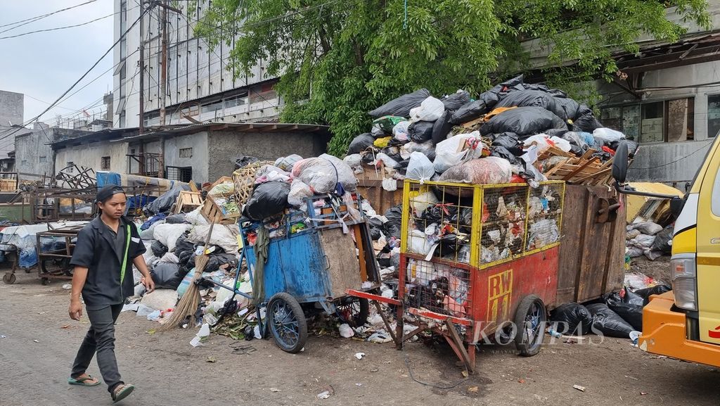 Seorang warga melintasi tumpukan sampah di sekitar Pasar Kosambi, Kota Bandung, Jawa Barat, Rabu (23/8/2023). Tumpukan sampah ini dikhawatirkan semakin menggunung karena TPA Sarimukti terbakar dalam beberapa hari terakhir. 