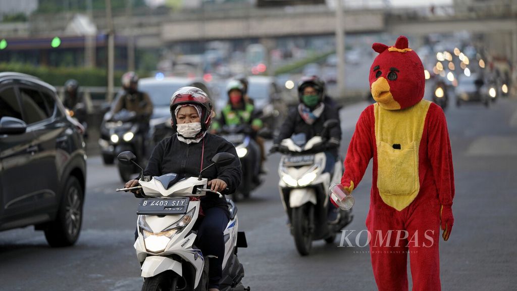 Badut Angry Birds berjalan gontai menunggu belas kasihan pengguna jalan di Jalan MT Haryono, Jakarta Timur, Rabu (8/7/2020). 